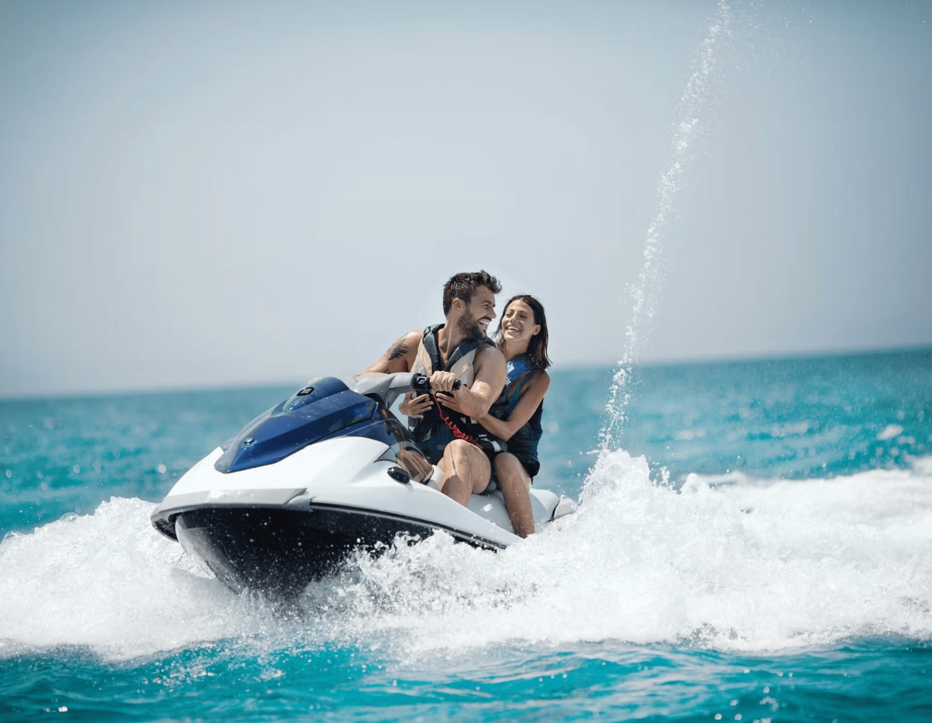 A joyful moment of a man and a woman riding a jet ski on the ocean