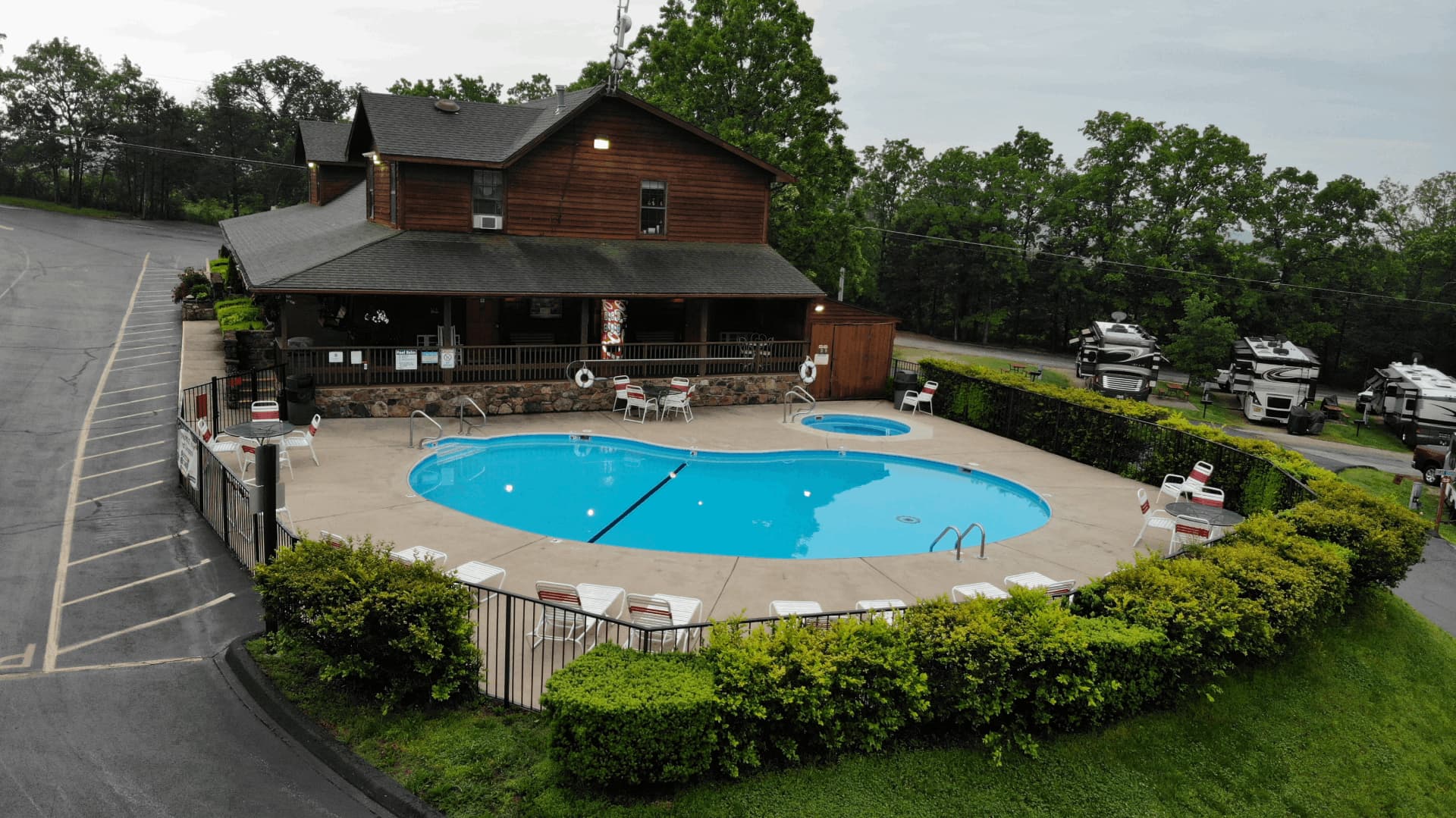 A swimming pool with a blue tint is surrounded by a fence