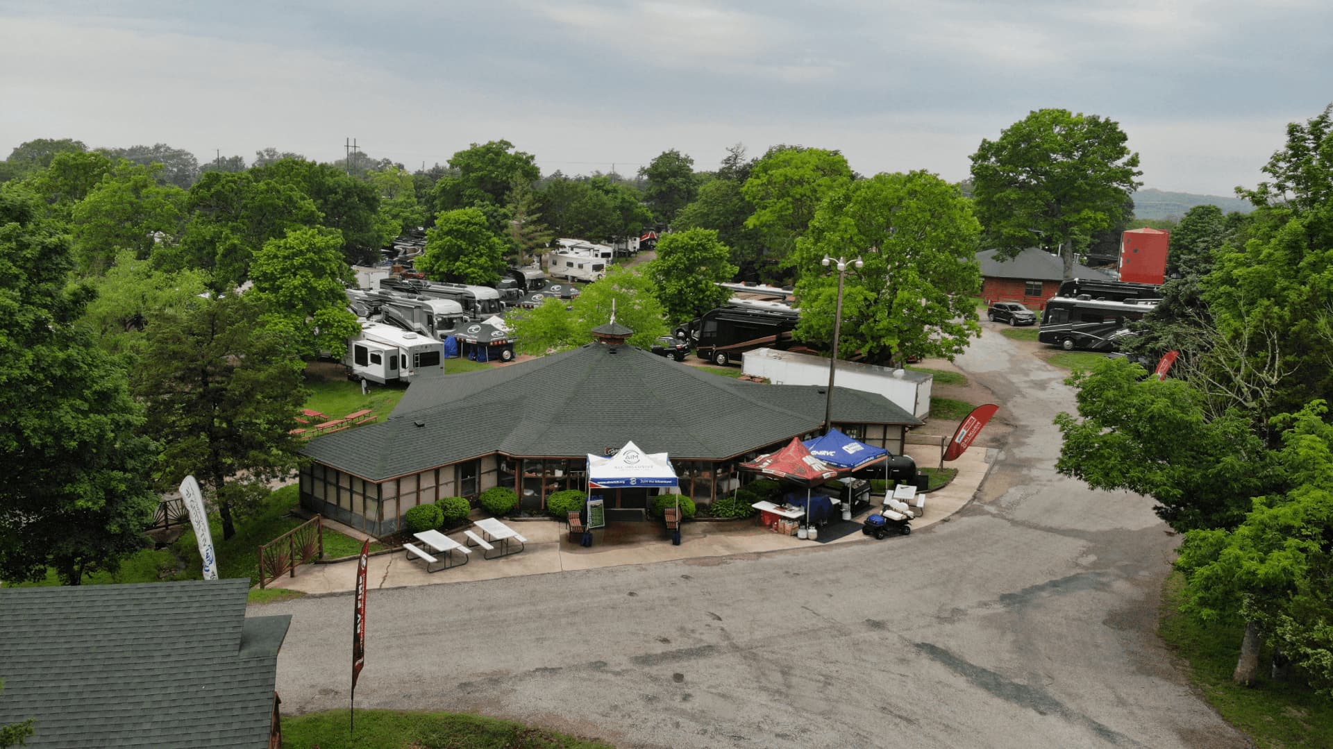 A campground with a large building, possibly a restaurant or a store, surrounded by trees