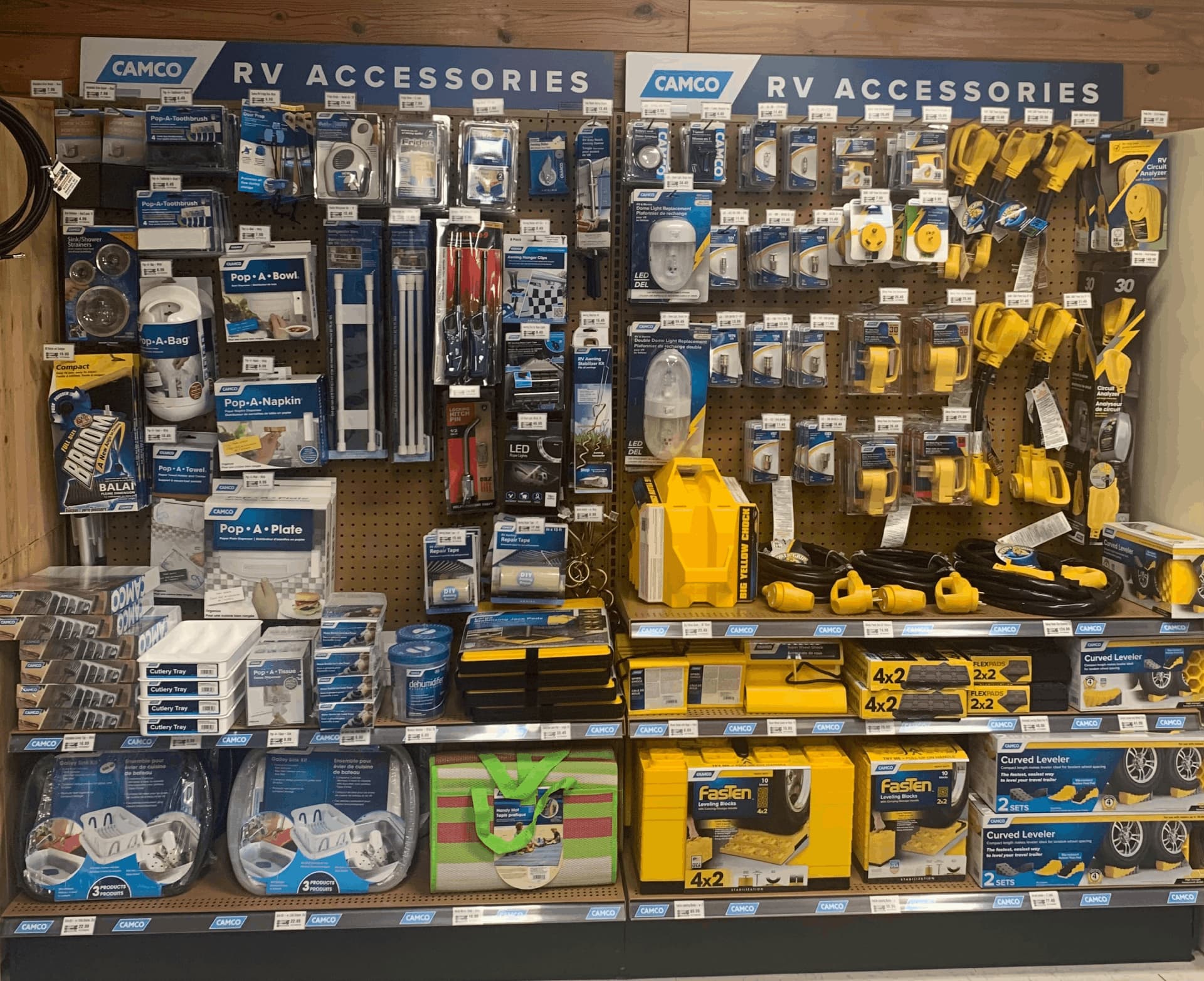 A display of various RV accessories is shown, including a yellow and black toolbox, a yellow and black toolbox with a green handle