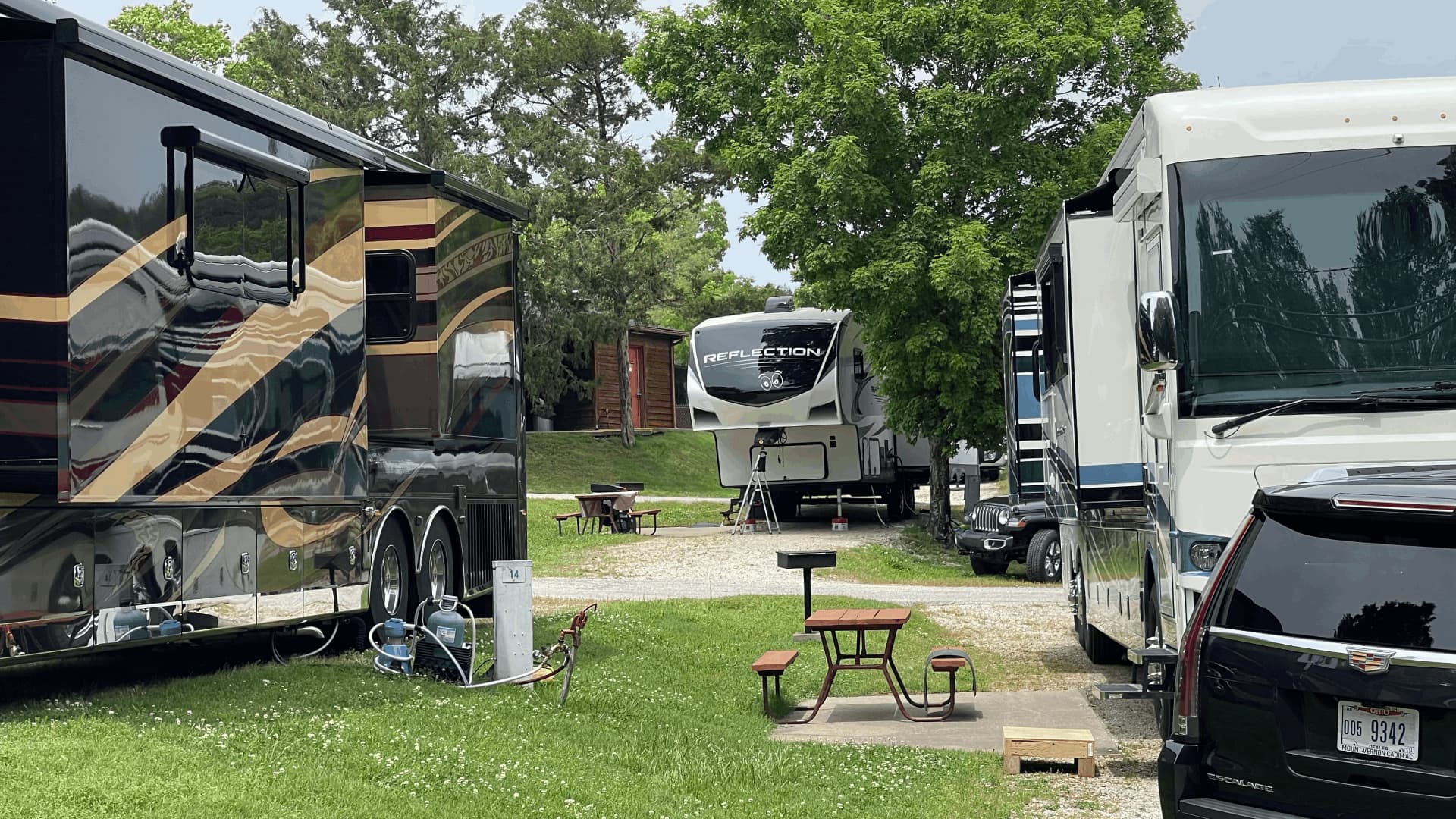 A black and silver recreational vehicle is parked in a grassy area
