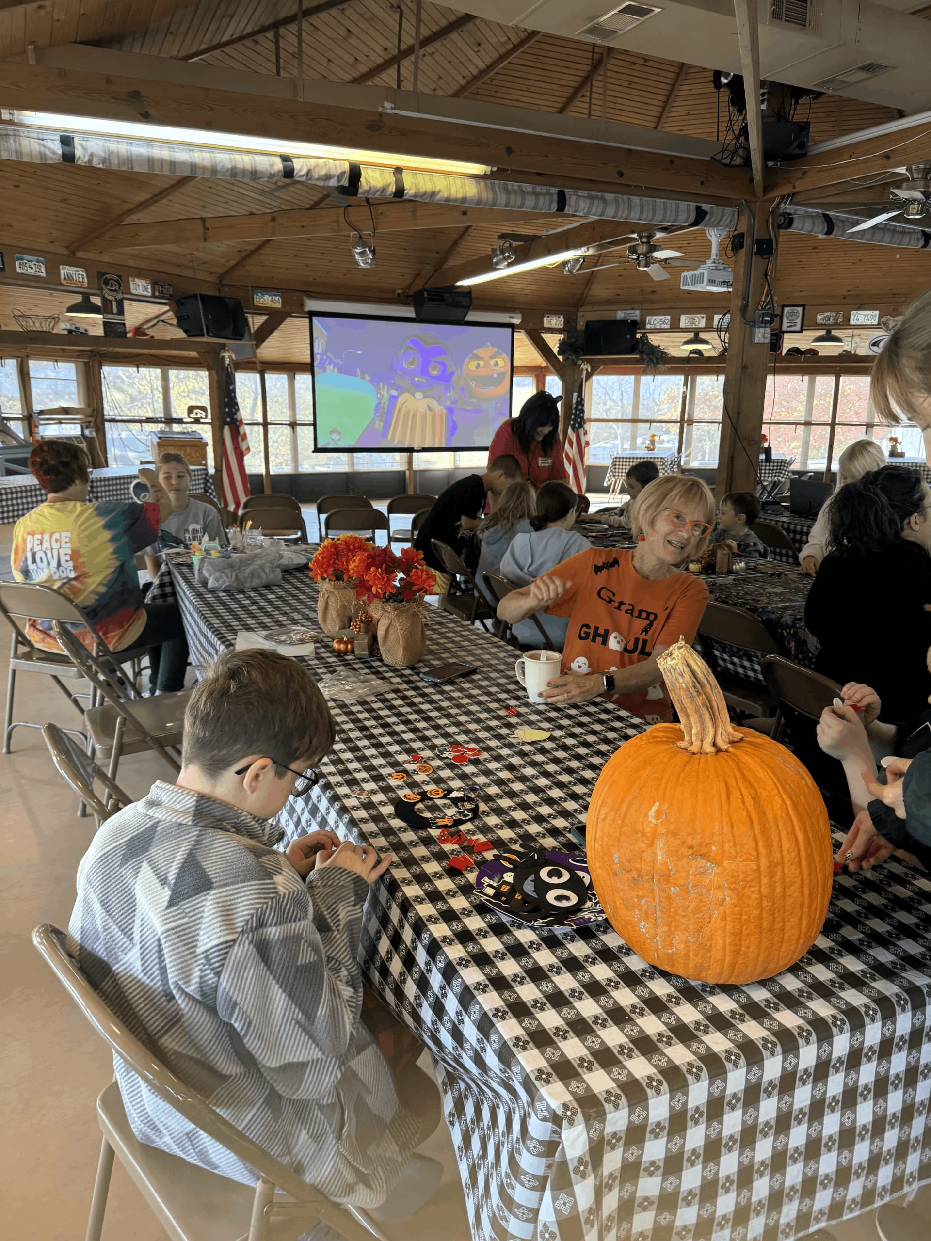 A group of people are sitting around a table with a pumpkin on it